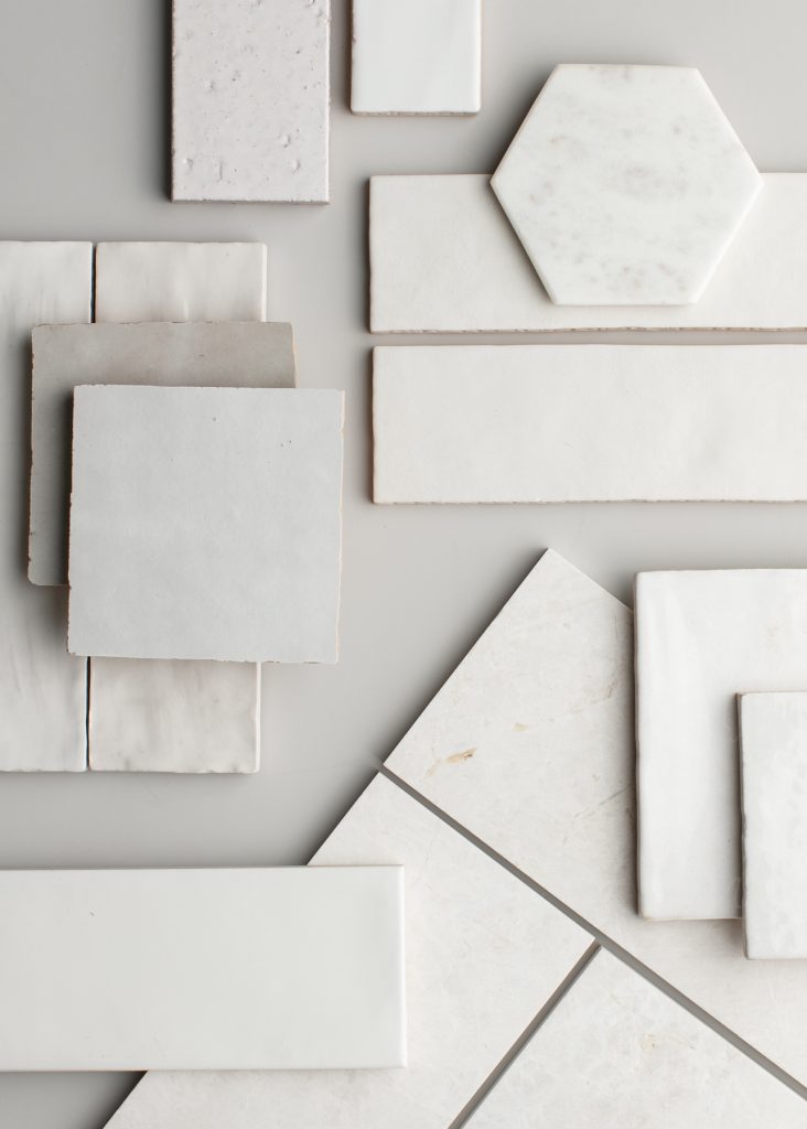 An assortment of white and light gray tiles in various shapes and sizes, including rectangles, squares, hexagons, and parallelograms, arranged on a neutral background.