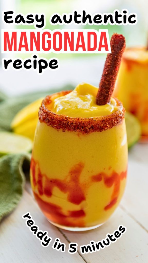 A glass of mangonada with chamoy and chili powder on the rim, topped with a tamarind stick, is shown on a white table with mango slices in the background. Text: Try this sweet and spicy drink—an easy mangonada recipe ready in 5 minutes.