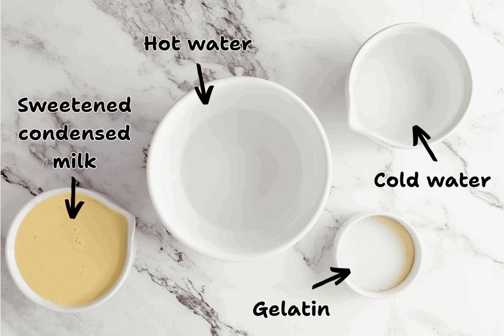 Four bowls on a marble surface labeled with arrows: one contains sweetened condensed milk, another hot water, another cold water, and the smallest holds gelatin—essential ingredients for festive 4th of July Jello Shots.