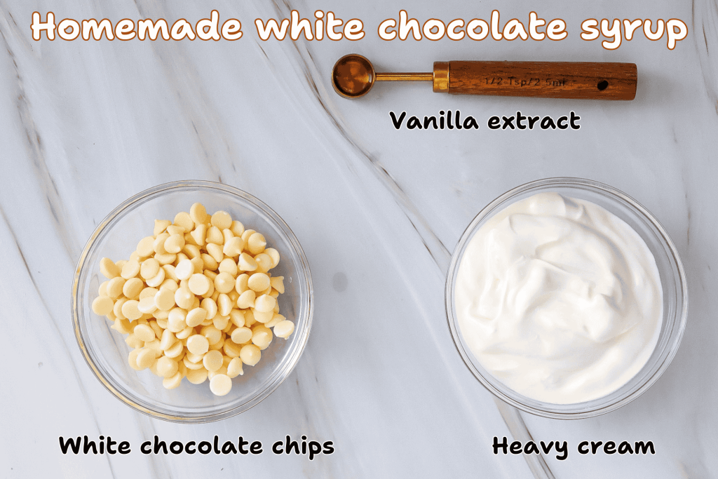 A flat lay showing ingredients for homemade white chocolate syrup—perfect for an iced white chocolate mocha: a glass bowl of white chocolate chips, one with heavy cream, and a wooden spoon with vanilla extract on marble. Text labels each ingredient.