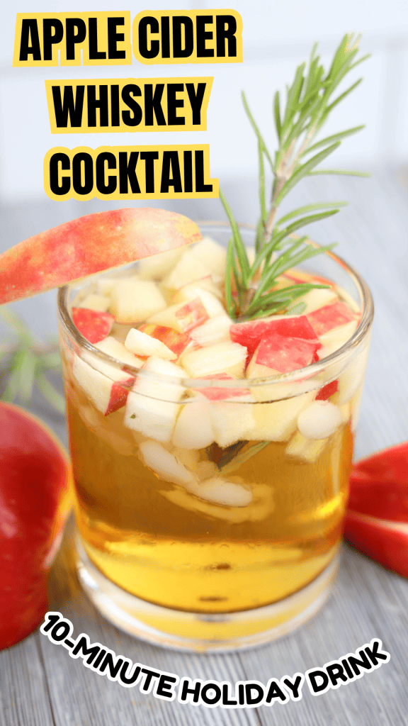 A glass of Christmas Apple Cider Cocktail featuring whiskey, garnished with chopped apples, an apple slice, and rosemary. Text reads: Apple Cider Whiskey Cocktail and 10-Minute Holiday Drink. Apples are visible beside the glass.