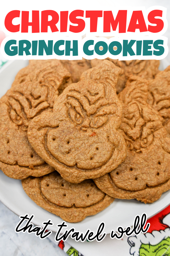 A plate of grinch themed cookies shaped like the Grinch’s face is shown, with the text “CHRISTMAS GRINCH COOKIES that travel well” above and below. The brown cookies feature detailed facial features.