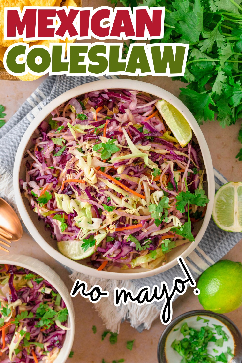 A bowl of colorful Mexican slaw no mayo with shredded cabbage, cilantro, and lime slices. Text on image reads Mexican Coleslaw and no mayo! Fresh cilantro and lime wedges are on the table.