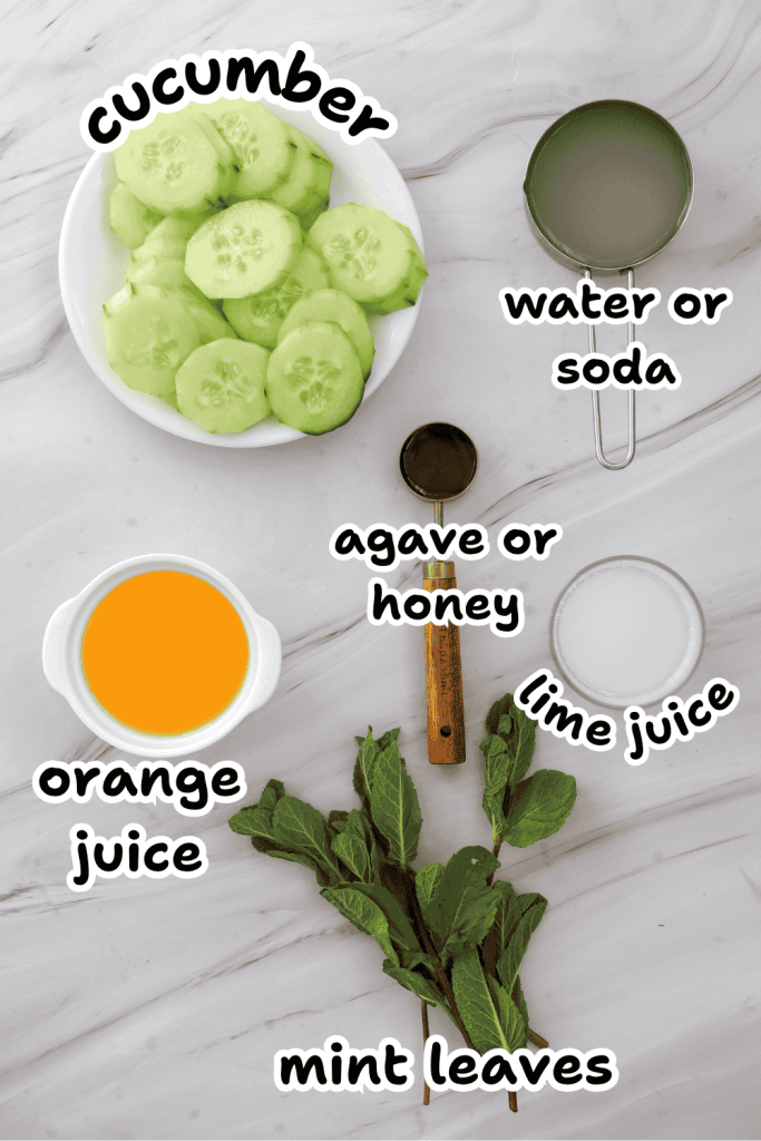 Sliced cucumber, orange juice, agave or honey, lime juice, water or soda, and fresh mint leaves arranged on a marble surface—perfect ingredients for a refreshing Cucumber Lime Mocktail—each labeled with handwritten text.