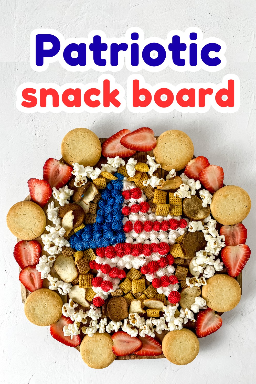 A round patriotic snack board arranged with cookies, popcorn, strawberries, and a central star made of red, white, and blue frosting, topped with the bold, colorful text “Patriotic snack board” for a festive touch.