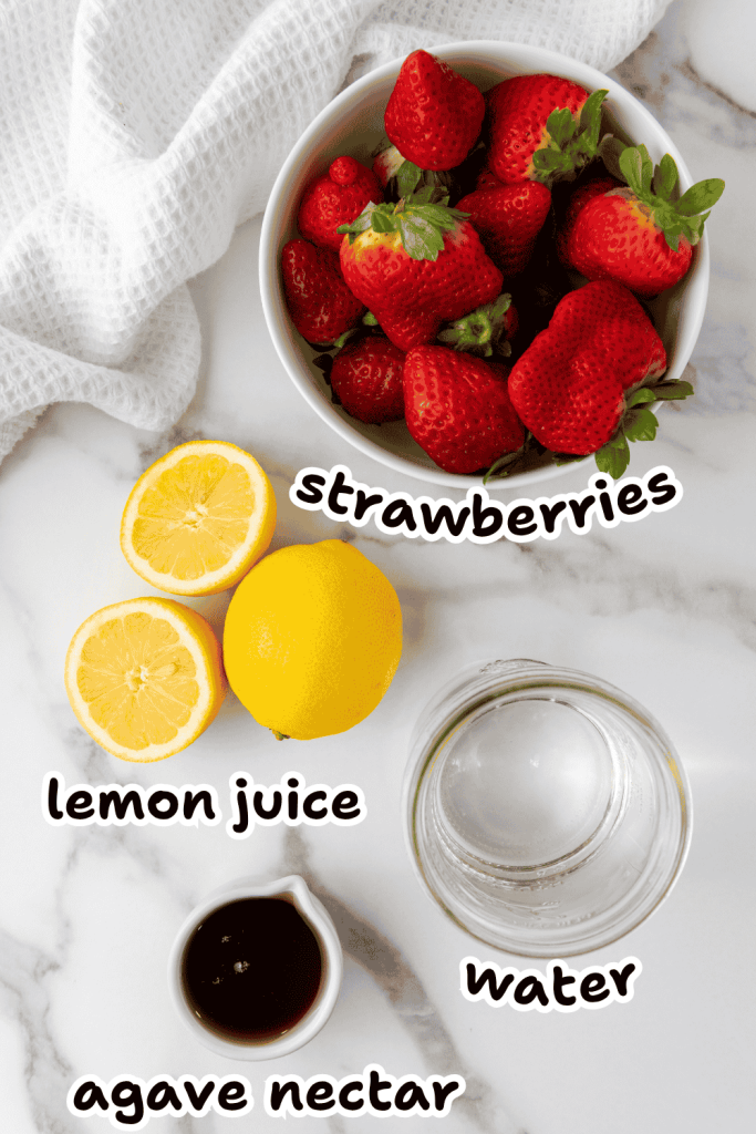 Flat lay of ingredients for Strawberry Lemonade Ice Pops: a bowl of strawberries, halved lemon, pitcher of water, and agave nectar on marble surface, each clearly labeled—perfect for an easy strawberry popsicles recipe.