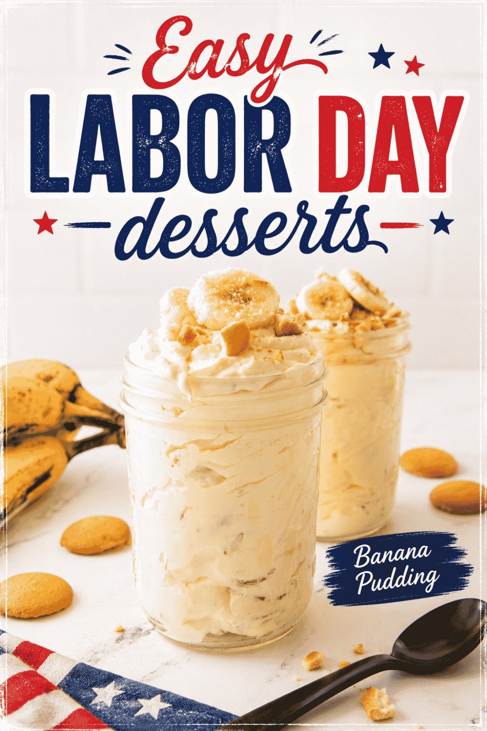 Two mason jars filled with banana pudding, topped with banana slices and cookies, sit on a white surface surrounded by extra cookies, bananas, and a patriotic cloth. Text reads: Easy Labor Day Desserts—Banana Pudding.