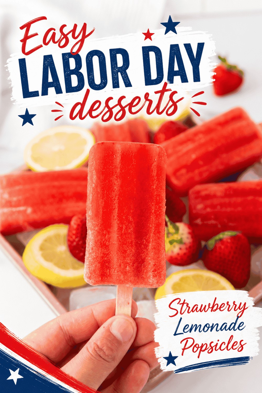A hand holds a red popsicle in front of sliced lemons and strawberries. Text reads: Easy Labor Day Desserts—Strawberry Lemonade Popsicles. Red, white, and blue stars decorate the image, highlighting this delicious addition to your list of easy Labor Day desserts.
