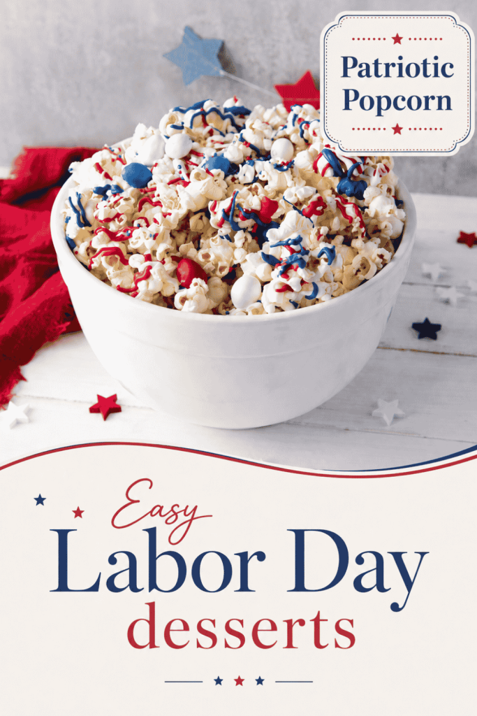 A white bowl of popcorn decorated with red, white, and blue candy sits on a white surface with festive star confetti. Text reads: “Patriotic Popcorn” and “Easy Labor Day Desserts,” making this treat a fun and festive addition to your holiday celebrations.