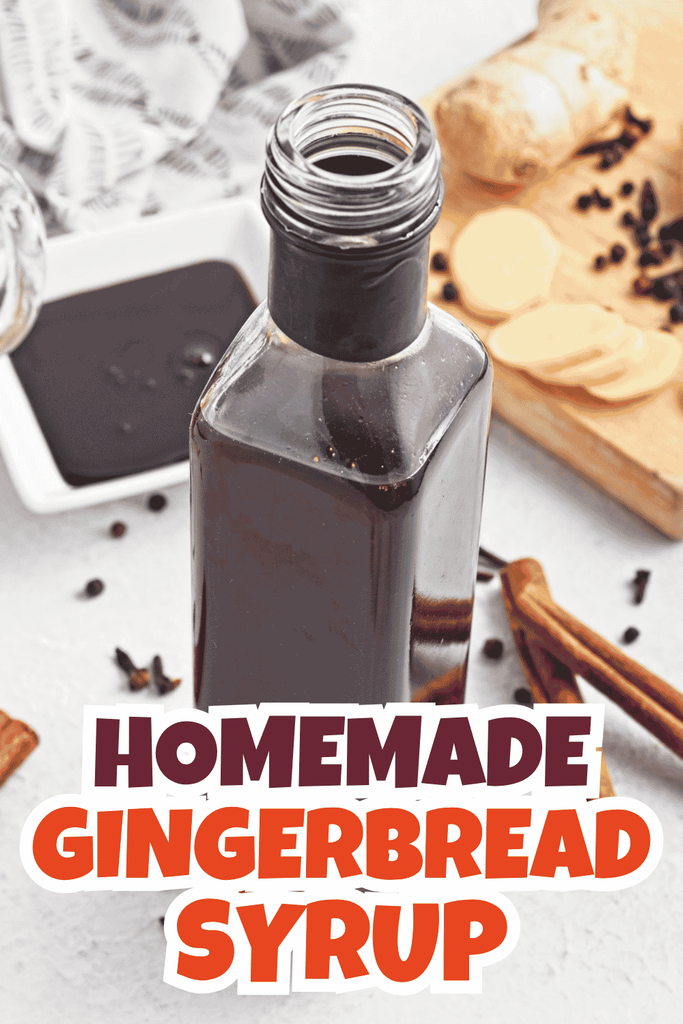 Open bottle of dark gingerbread syrup on a table with sliced ginger, spices, and a bowl of syrup nearby. Text overlay reads, Homemade Gingerbread Syrup.