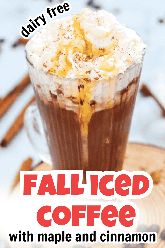 A glass of iced coffee topped with whipped cream, maple syrup, and a sprinkle of cinnamon captures the essence of Fall Iced Coffee. Text reads: dairy free FALL ICED COFFEE with maple and cinnamon. In the background, cinnamon sticks add a cozy autumn touch.