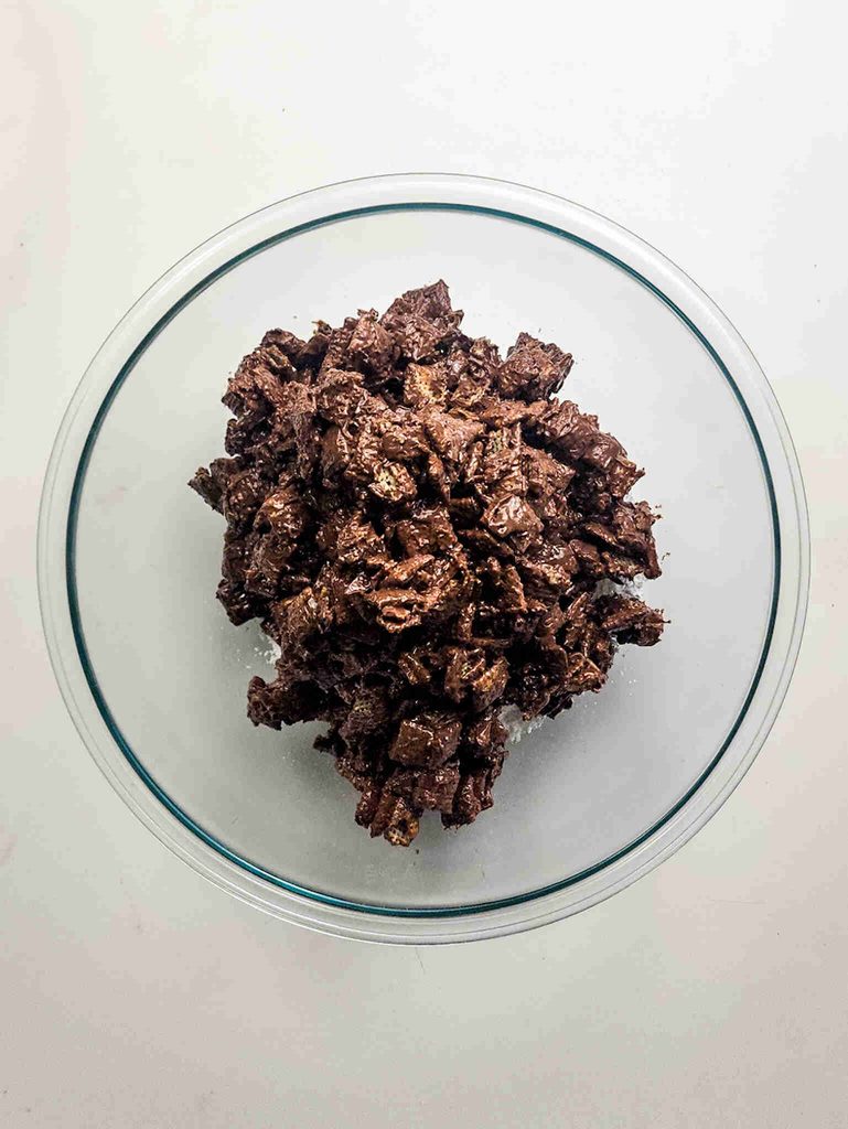 A glass bowl filled with chunks of reindeer munch, a dark chocolate-coated cereal.
