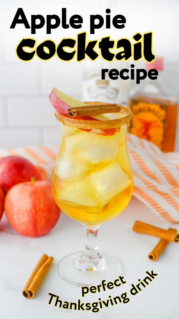 Apple pie cocktail in a glass with ice, garnished with a cinnamon stick and apple slice, with apples and cinnamon sticks nearby. This Thanksgiving vodka drink is labeled with text overlays for an apple pie cocktail recipe and perfect holiday drink.
